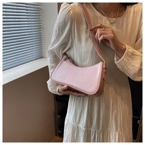 Detailed view of pink French style shoulder bag with fine texture and crescent shape