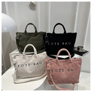 Detail of four colorful corduroy tote bags with embroidery and adjustable straps