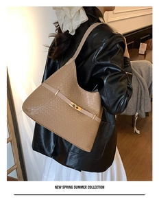 Close-up of khaki woven texture hobo bag with gold metal buckle on a model
