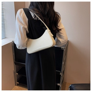 Detail of white leather shoulder bag with JUST & MEPAI logo and minimalist half-moon shape