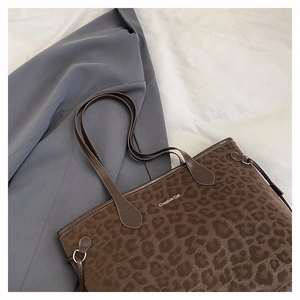 Detail of leopard print suede tote bag with Creative Cat text and leather handle