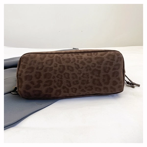 Detail view of the flat base and leopard print suede texture of the large tote bag