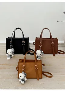 Dettaglio delle borse vintage in nero, caffè e marrone con ciondoli di peluche morbidi
