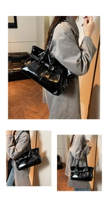 Detail of glossy patent leather tote bag with stylish buckle straps and slim shoulder straps