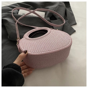 Macro shot of pink shimmering fabric texture on a minimalist handbag with top handle