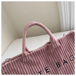 Close-up of pink corduroy tote bag featuring thick handles and silver D-ring buckle