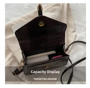 Detail showing internal capacity of deep brown crocodile texture crossbody square bag