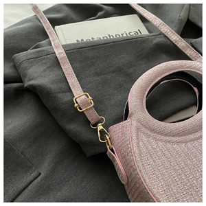 Close-up of glitter fabric handbag with circular cutout handle and golden metal buckles