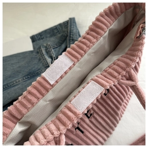 Detail of pink corduroy tote bag featuring secure velcro closure and interior lining