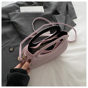 Pink textured handbag with vertical stripes and inner zipper pocket on a blazer