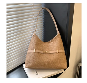 Close-up of tan crocodile-embossed shoulder bag with elegant golden hardware lock