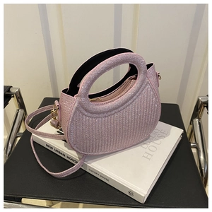 Close-up of pink sequined handbag showing vertical ribbed texture and gold metal hardware