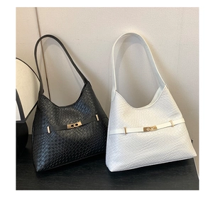 Detailed view of woven texture and golden metal buckle on black and white shoulder bags