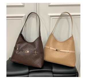 Detail of woven texture leather hobo bags with gold metallic twist lock buckle in macro view
