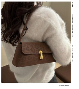 Side view of leopard print baguette bag with gold metal buckle on white mohair sweater