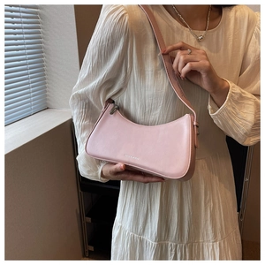 Pink crescent underarm bag in smooth faux leather with silver zipper detail and logo
