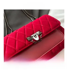 Macro detail of red velvet quilted handbag featuring a metallic rockstud clasp
