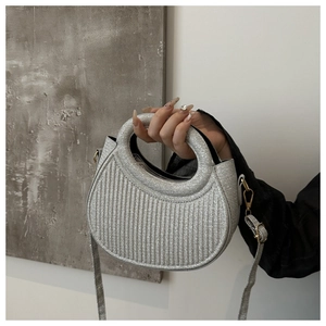 Close-up of silver sequined handbag featuring vertical textures and detachable shoulder strap