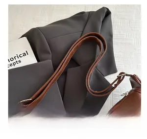 Détail de la bandoulière réglable en cuir marron caramel avec boucle en métal argenté