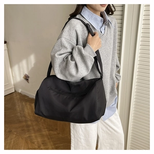Gros plan du sac oreiller en nylon noir avec bandoulière réglable et fermeture éclair