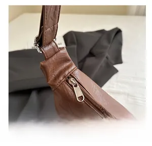 Gros plan sur la fermeture éclair en métal et la texture cuir du sac fourre-tout marron