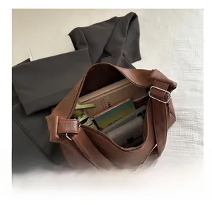 Vue de dessus d'un grand sac hobo marron montrant l'intérieur spacieux et accessoires