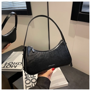 Detailed close-up of glossy black hobo bag with silver zipper and fine wrinkled texture