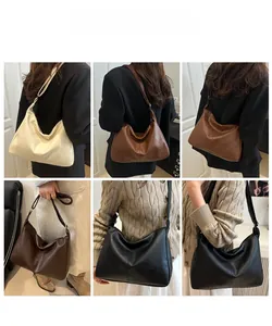 Gros plan sur le grain de cuir litchi et la boucle réglable du sac cabas rétro