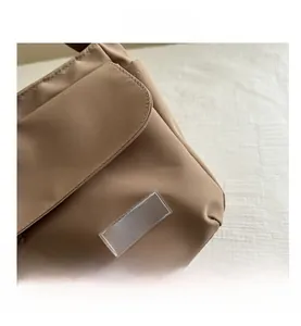 Dettaglio della borsa messenger kaki con tasca a patta e toppa in gomma trasparente FASHION