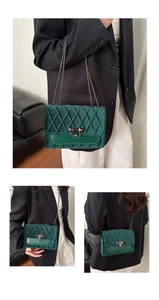 Detail of dark green velvet crossbody bag with quilted pattern and gunmetal chain strap