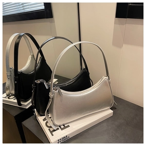 Detail of silver crescent shoulder bag with metallic finish and smooth zipper closure