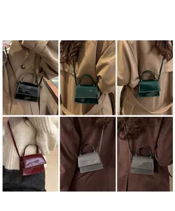 Detail view of mini glossy patent leather handbag showing four colors and trapezoid design