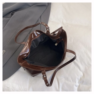 Deep brown glossy tote interior featuring a zippered pocket and black lining