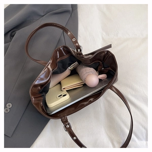 Detailed interior of the brown glossy tote bag showing large capacity for laptop and daily items