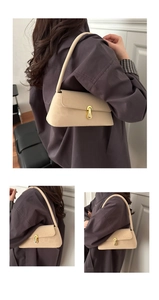 Detail of minimalist cream leather underarm bag with elegant gold oval mechanical lock