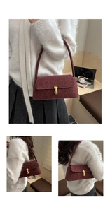 Detail of burgundy leopard print underarm bag with gold metal clasp on plush sweater