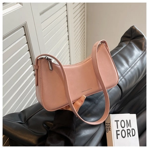 Detail of a pink leather hobo bag with silver zipper and slim strap in a stylish setting