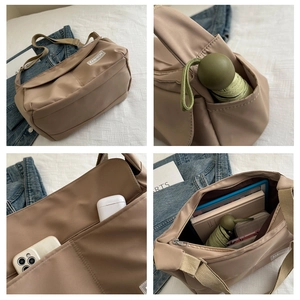 Dettaglio borsa a tracolla in nylon kaki con scomparti interni e tasche laterali esterne