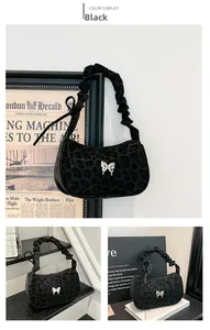Detail of leopard print hobo bag featuring a silver butterfly charm and ruched handle