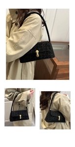 Detail view of black leopard pattern shoulder bag with golden U-shaped buckle and suede texture