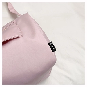 Close-up of pink nylon fitness bag featuring a black Fashion woven label and strap