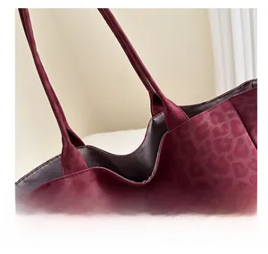 Detail of burgundy leopard print tote bag showing stitching and gray inner lining