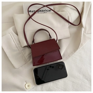 Miniature burgundy tote bag with glossy patent leather and smartphone size reference