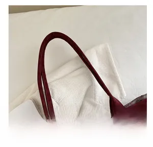 Close-up detail of reinforced slim handles and dark leopard pattern on faux leather tote bag