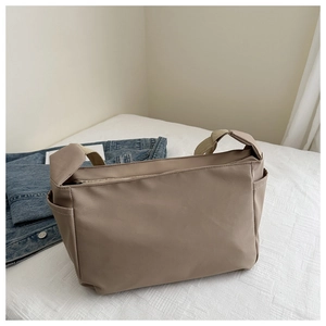 Detail of khaki nylon tote bag showing smooth waterproof fabric and side pocket