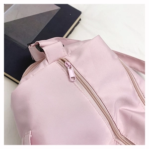 Detail view of smooth pink waterproof nylon fabric and matching tone metal zipper