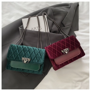 Detail of vintage velvet quilted crossbody bags in dark green and burgundy with metal chains