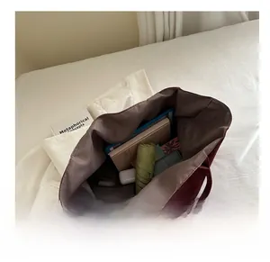 Large burgundy tote bag with spacious interior showing storage for daily essentials