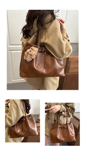 Brown faux leather tote bag detail with decorative strap and plush dog keychain