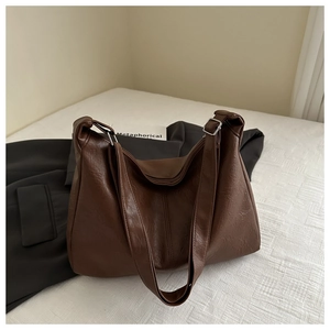 Gros plan d'un sac cabas en cuir PU marron foncé avec boucle argentée réglable